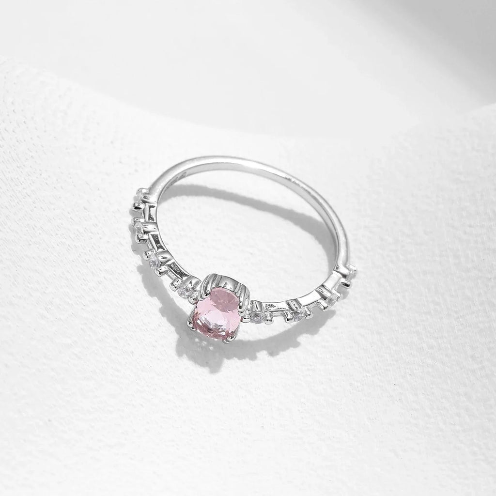 Anel solitário oval em prata 925 com pedra rosa e detalhes em zircônia em fundo branco